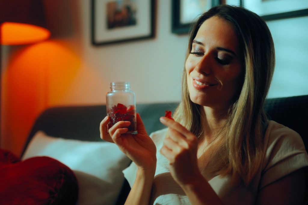 A lady is eating mushroom gummies for relaxation