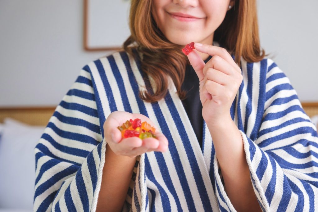 A lady is eating small amount of road trip mushroom gummies