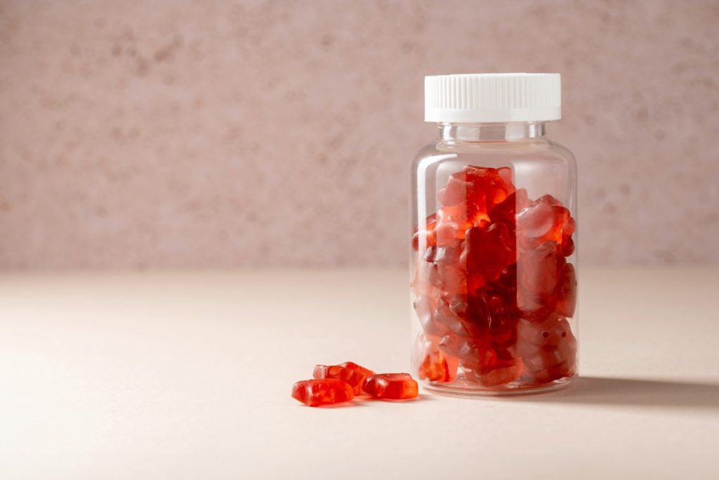 Jar of legal mushroom gummies with some gummies placed in front